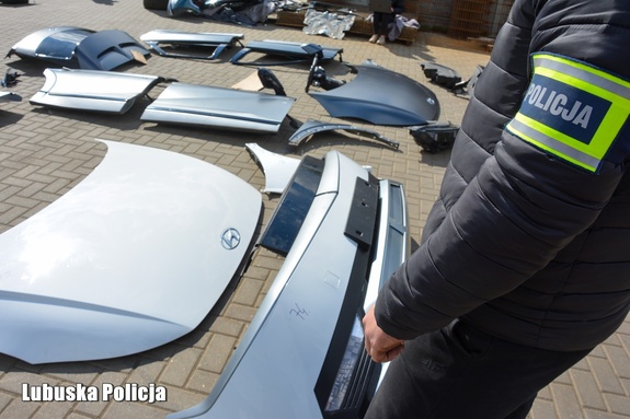 policjant i zabezpieczona część samochodowa
