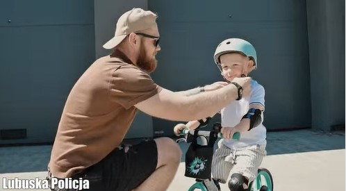 mężczyzna zakłada dziecku kask