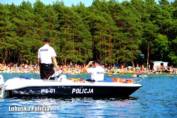 policjanci na łodzi nad wodą